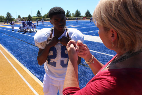 Freshman Tyler Berry communicates with interpreter Gloria Jarrell while he takes a break from football practice.