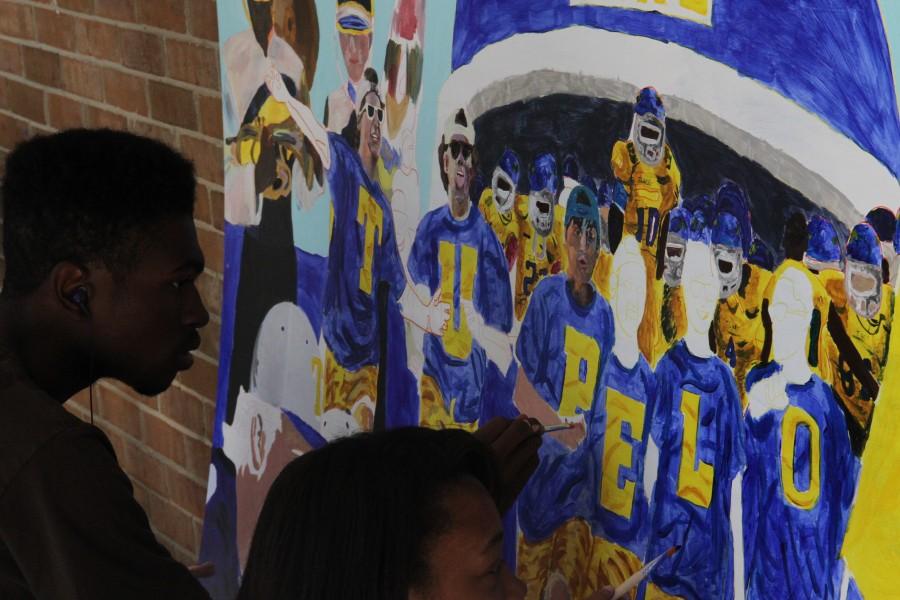 Tupelo High School students Zack McIntosh, left, and Keondra Thomas paint the Tupelo Boys on a mural that highlights school spirit.