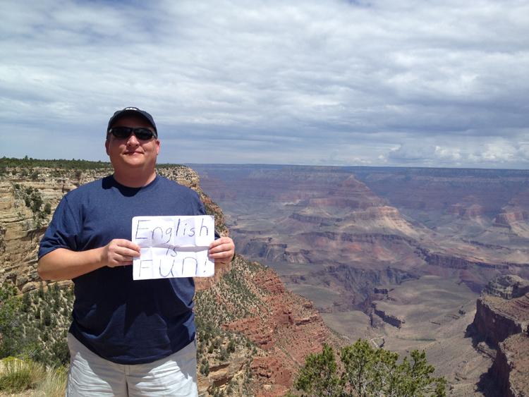 Rand Hinds holds up an “English Is Fun” sign at the Grand Canyon in July 2015. 
