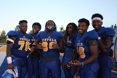 Senior football players all pose for the camera.