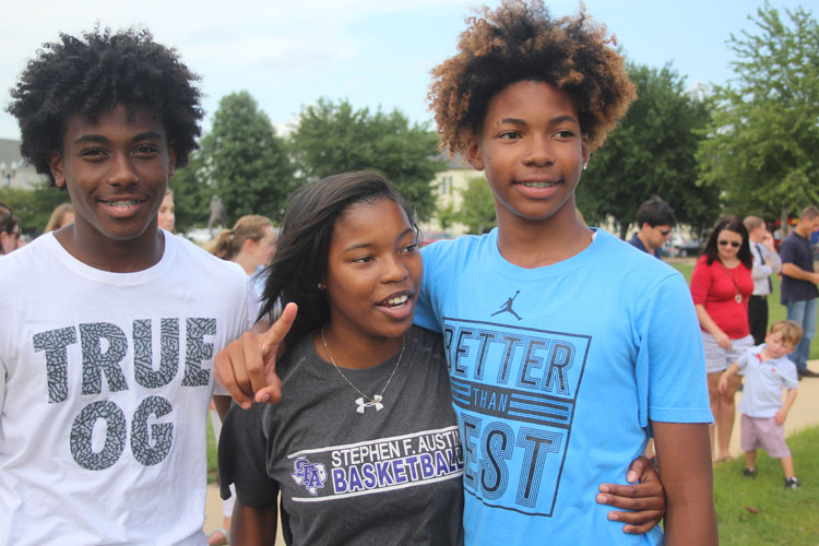 Bryson Wilson, sophomore, Halle Traylor, freshman, and Kamron Anderson, freshman posing at the city pep rally. 