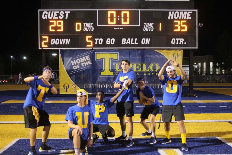 TUPELO boys posing in front of the scoreboard to show school spirit 
