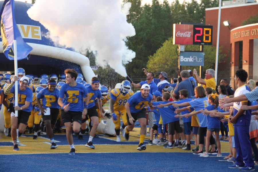 The TUPELO boys lead the footballs players out on the field