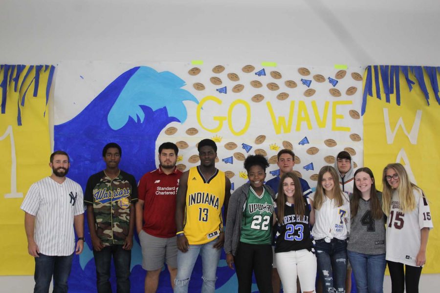 Coach Davis third block class posing in front of the poster in H Commons for Jersey day
