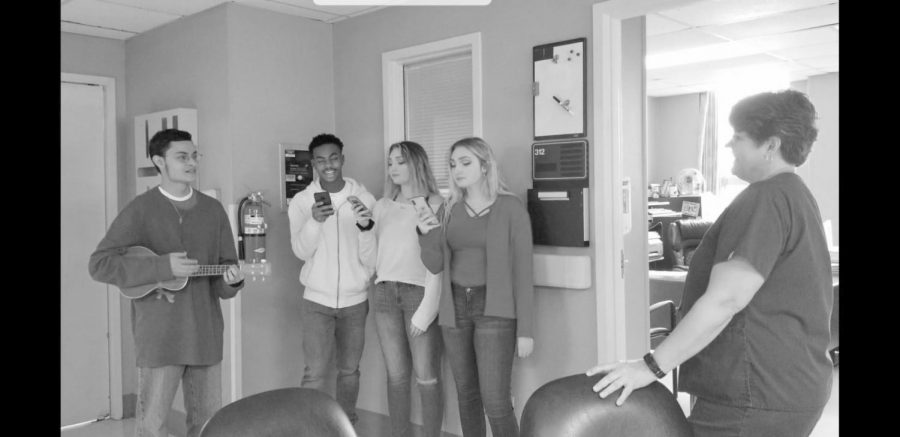Senior Cole Herrington plays the Ukelele with Malik Small, Claire Burroughs and Cate Burroughs as they seranade a lucky valentine. 