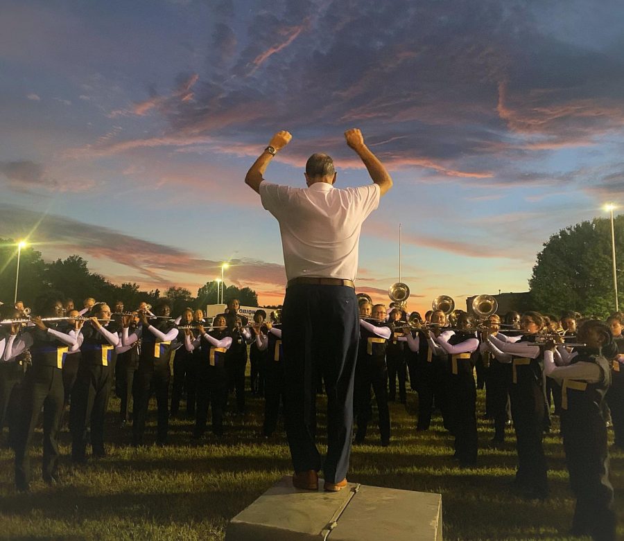 Band Director Rick Murphy warms the band up in a practice field before the competition.    