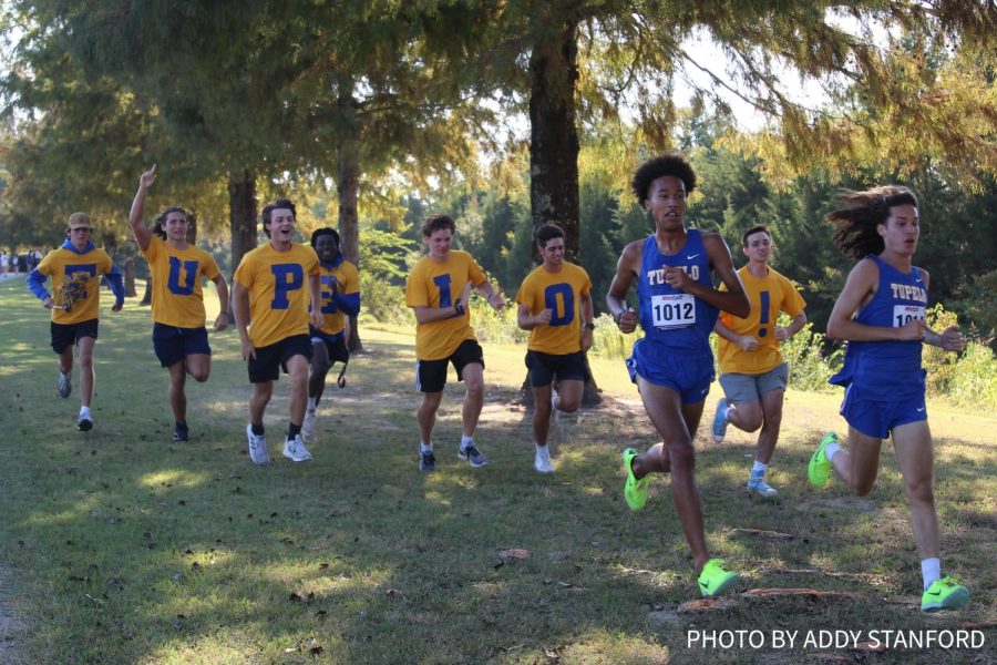 The+TUPELO+boys+cheer+on+and+run+with+runners+Jaheim+Bridges+and+Taylor+Brown+as+they+take+first+overall+and+win+the+boys+4-6A+race.