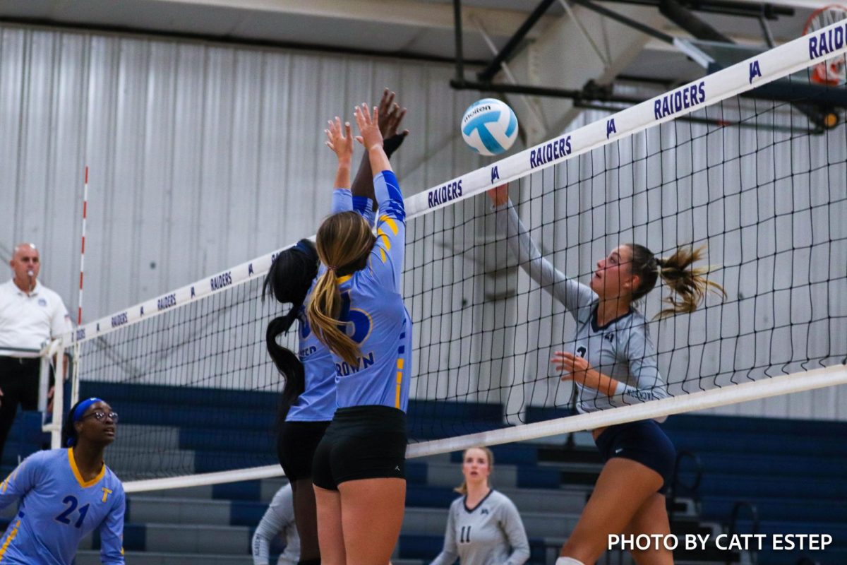 Kinslee Carter and Sarah Foster Brown block the ball from the opposing teams hit. 