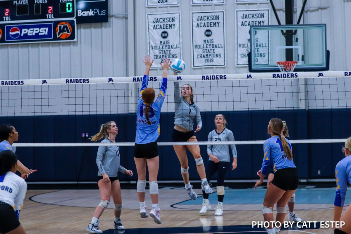 Loren Zimmerman jumps up to block the hit from Jackson Academy. 