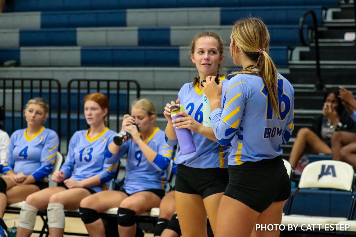 Gracie Hopkins and Sarah Foster Brown get water as they discuss the game during a timeout. 