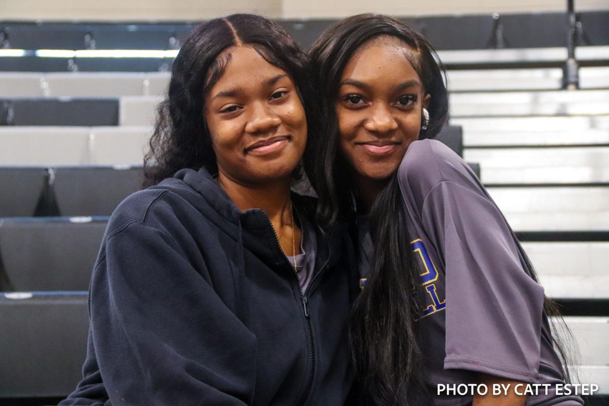 Kai Glover and Kamryn Harris pose on the bleachers to show support for their team. 