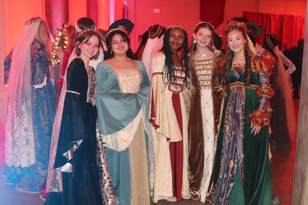 Andrea Laman, Isabelle Rutland, Alyssa Arnold, Alania Laman, and Claudia Baylock gather in their traditional European gowns and headdresses. These outfits date back to the 1400s to 1500s.