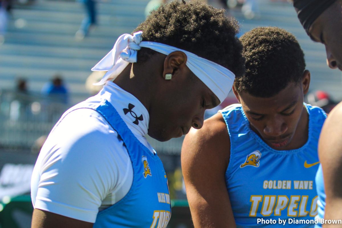 Brailin Hodges praying with his 4x100 team